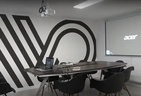 Conference room with Virtoffice logo, black table, and projector.